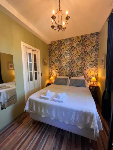 a bedroom with a bed and a chandelier at Hotel Le Ponteil in Antibes