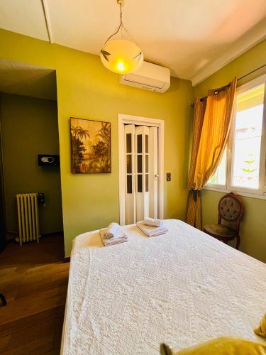 a bedroom with a bed with two towels on it at Hotel Le Ponteil in Antibes