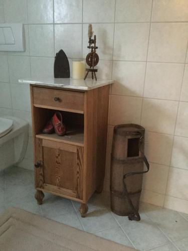 a bathroom with a wooden table and a trash can at Das Sunnhäusl in Mariapfarr