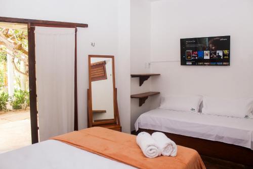 a room with two beds with towels on a table at Pousada Morada do Sol in Jericoacoara