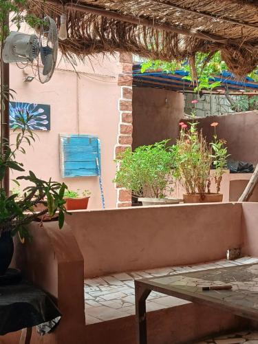 an outdoor patio with potted plants and a table at "Par 4 Chemins" - Atypical stopover in Nouakchott