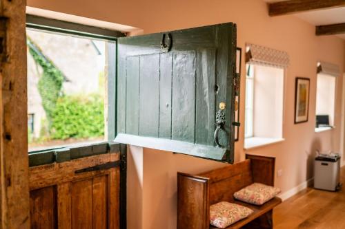 a large wooden door in a room with a window at The Dovecot in Salisbury