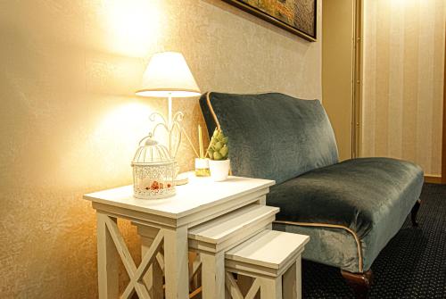 a room with a chair and a table with a lamp at Hotel dos Loios in Santa Maria da Feira