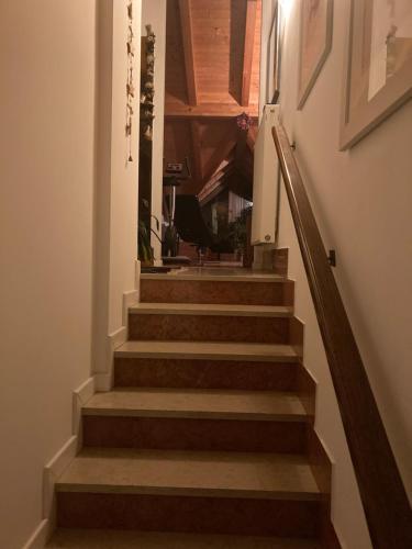 a stairway with wooden stairs in a building at La mansarda di zia Elena in Civezzano