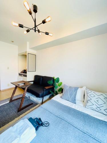 a living room with a bed and a table at Alo BnB 12 - Game Universe - Easy Access to Shibuya - New ! in Tokyo