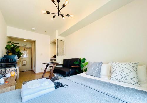 a bedroom with a large bed and a chair at Alo BnB 12 - Game Universe - Easy Access to Shibuya - New ! in Tokyo