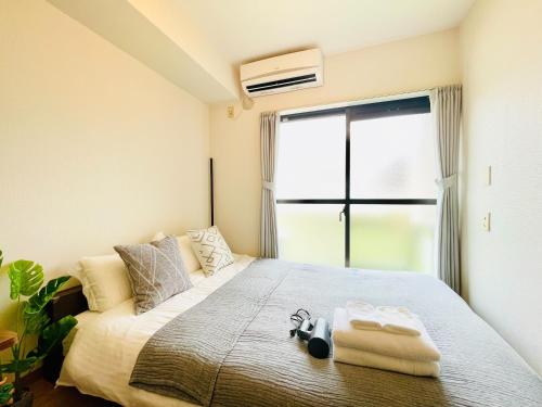 a bedroom with a bed and a large window at Alo BnB 12 - Game Universe - Easy Access to Shibuya - New ! in Tokyo
