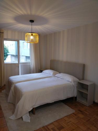 a bedroom with a large bed and a chandelier at Fonteculler in Fonte Culler