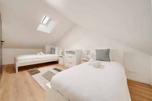 une chambre blanche avec un lit blanc et une fenêtre dans l'établissement L'éclat de Gambetta - Place Stanislas - 6 Pers, à Nancy