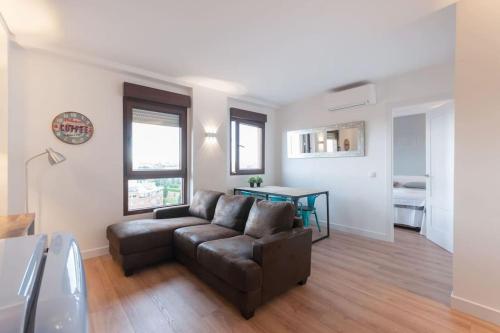 una sala de estar con un sofá y una mesa en ºººCH Residential Area Modern City Views WiFi ACººº, en Madrid