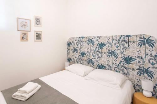 une chambre avec un lit avec un papier peint fleuri dans l'établissement L55 2P central Jean Médecin 10 min à pied Vieux Nice, à Nice