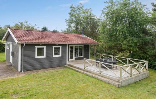 a small house with a large deck in the yard at Gorgeous Home In Fårvang With Wifi in Fårvang