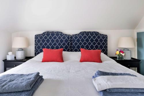 a bedroom with a large bed with two red pillows at Finest Retreats - Coach House Wellbeing Retreat in Pen y Clawdd