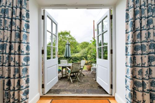 an open door to a patio with a table and chairs at Finest Retreats - Coach House Wellbeing Retreat in Pen y Clawdd