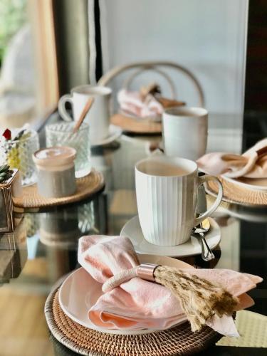 a glass table with plates and cups and napkins at Cabañas Puente Negro in Puente Negro