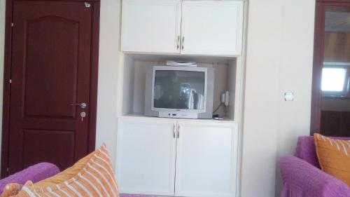 a living room with a tv in a white cabinet at Rose Apart in Sarigerme