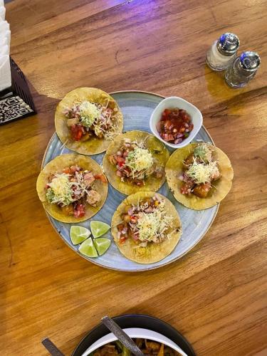 a tray with four pizzas on a wooden table at El Jardín Escondido by Soma in Baños