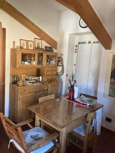 a kitchen with a wooden table and two chairs at La mansarda di zia Elena in Civezzano