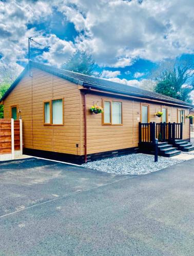 a small wooden house with a fence in a parking lot at Elder Cabin with Hot Tub in York