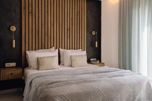 a bedroom with a large bed with two pillows at Xenia, Relaxing Pool Villa in Gaïtánion