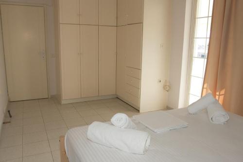 a white bedroom with a bed with towels on it at Kalamata 360 View in Kalamata