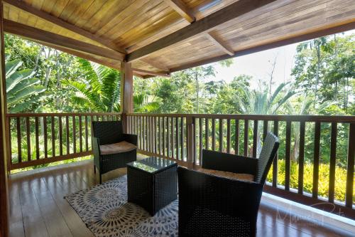 a screened in porch with chairs and a table at Luxury Villa Panorama Verde Pool House in Punta Uva