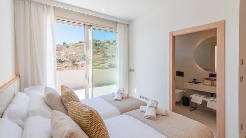 ein Hotelzimmer mit zwei Betten und einem großen Fenster in der Unterkunft Villa Horizon Antequera by Ruralidays in Antequera