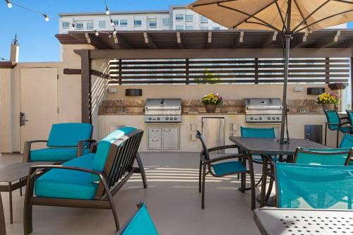 a patio with a table and chairs and a kitchen at Peacock Suites in Anaheim