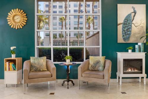 a living room with two chairs and a fireplace at Peacock Suites in Anaheim