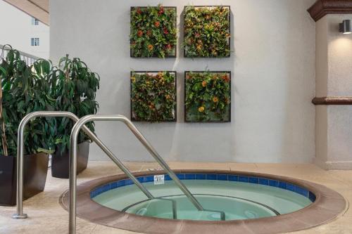 a hot tub in a room with plants on the wall at Peacock Suites in Anaheim