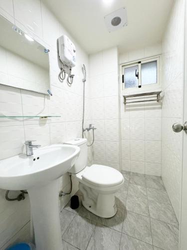a white bathroom with a toilet and a sink at 逢甲玖壹住宿 Fengjia 91 house in Taichung