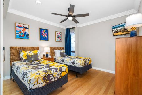 a bedroom with two beds and a ceiling fan at Updated 2bd 2ba Maui Vista Condo with Ocean View in Kihei