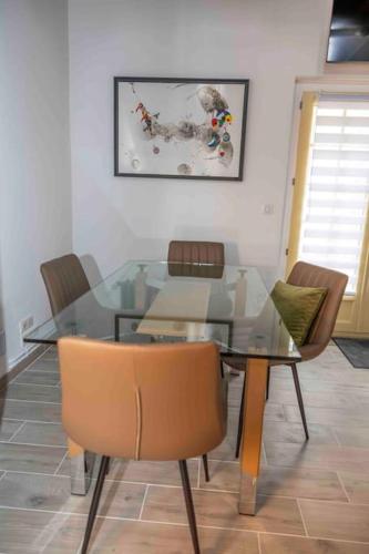 - une table à manger en verre et des chaises dans la pièce dans l'établissement Le Repaire, à Montigny-le-Gannelon