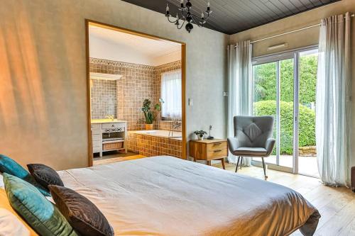 - une chambre avec un lit, une chaise et une baignoire dans l'établissement Magnifique Villa avec dépendance à 700m de l'océan, à Les Sables-dʼOlonne