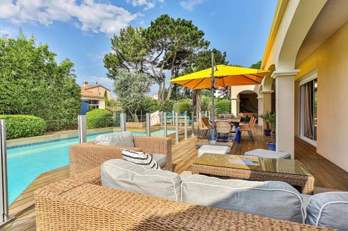 d'une terrasse avec des meubles en osier à côté d'une piscine. dans l'établissement Magnifique Villa avec dépendance à 700m de l'océan, à Les Sables-dʼOlonne