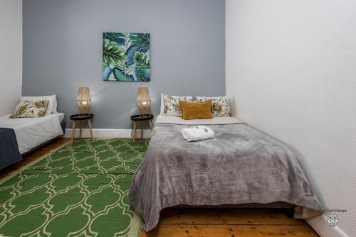 a bedroom with a bed and a green rug at The Owl House Guest House in Port Elizabeth