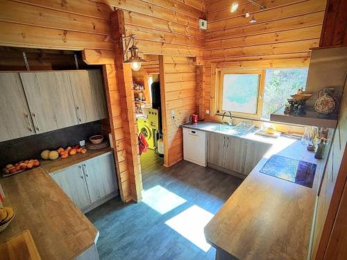 - une cuisine dans une cabane en bois avec un comptoir dans l'établissement Les cigales magnifique maison en bois avec piscine, à Portel-des-Corbières