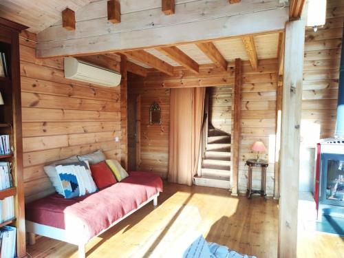 Cette chambre comprend un lit dans une cabane en bois. dans l'établissement Les cigales magnifique maison en bois avec piscine, à Portel-des-Corbières