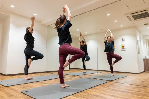 a group of women doing yoga in a room at Park Hotel Kyoto in Kyoto