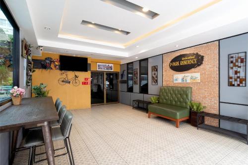 a waiting room with a table and chairs and a television at P-Park Hotel Bangkok in Bangkok
