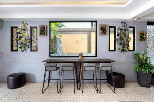 a dining room with a table and stools at P-Park Hotel Bangkok in Bangkok