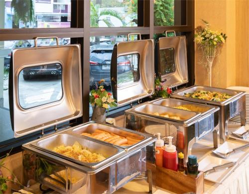 a buffet with three trays of food on a table at P-Park Hotel Bangkok in Bangkok