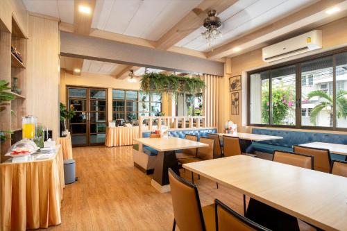 a dining room with tables and chairs and a restaurant at P-Park Hotel Bangkok in Bangkok