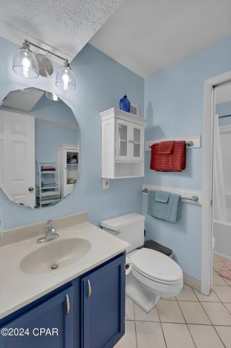 a bathroom with a toilet and a sink and a mirror at Sunset at Summit in Panama City Beach