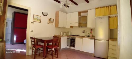 a kitchen with white cabinets and a table and chairs at Panigale90 in Bologna