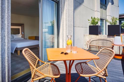 a table and chairs on a balcony with a bedroom at Novotel Paris Gare De Lyon in Paris