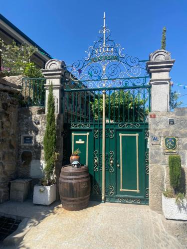a green gate with a barrel in front of it at Casa Major in Pegarinhos