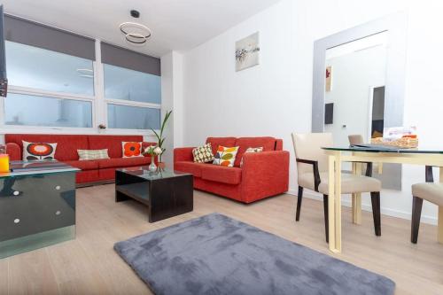 a living room with a red couch and a table at Flat 403 One bedroom apartment in Birmingham