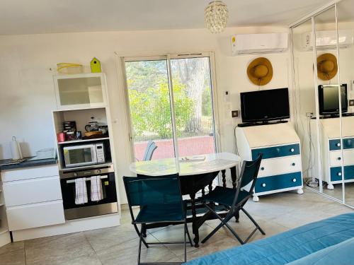 une cuisine avec une table et des chaises dans une pièce dans l'établissement Proches Lacs Rivières Canal du Midi Mer Méditerranéenne, à Lézignan-Corbières