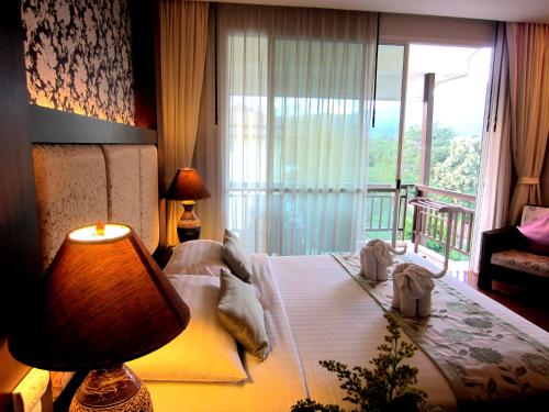 una stanza d'albergo con un letto e una finestra di Mountain Creek Wellness Resort Chiangmai a Chiang Mai